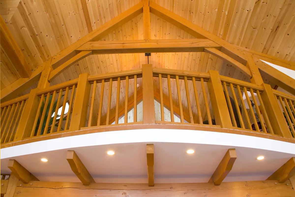 Rustic-finish timber trusses over a residential loft and balcony